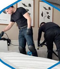 Twee schoonmakers van Schoonmaak Specialist reinigen een matras en bank